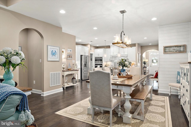 dining space with dark hardwood / wood-style flooring and a chandelier