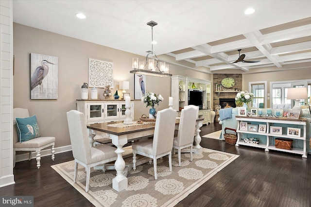 dining space featuring coffered ceiling, ceiling fan, beamed ceiling, a fireplace, and hardwood / wood-style floors