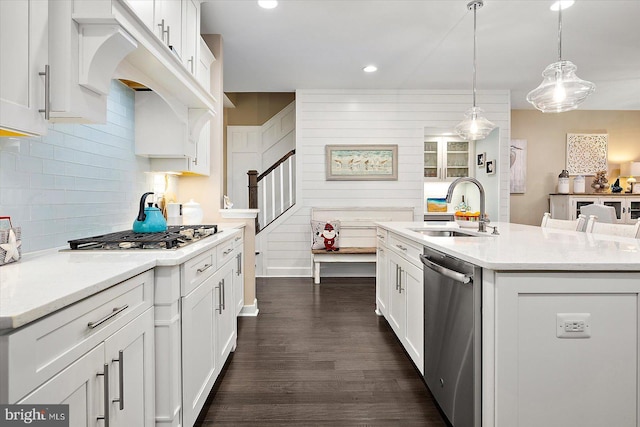 kitchen featuring white cabinetry, sink, hanging light fixtures, a center island with sink, and appliances with stainless steel finishes