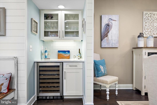 bar with white cabinets, decorative backsplash, wine cooler, and dark wood-type flooring