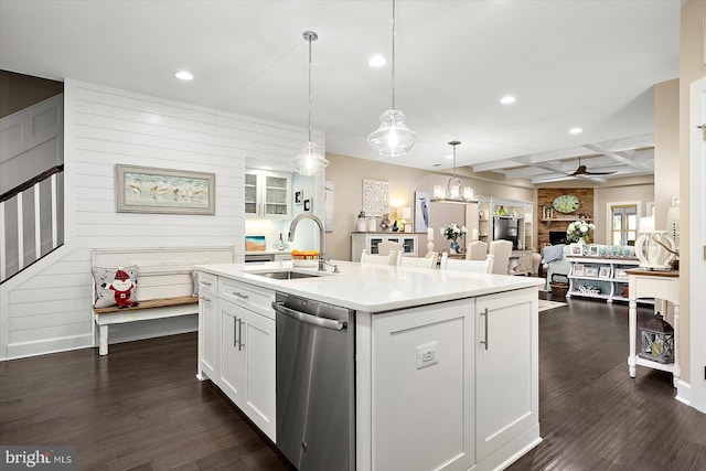 kitchen featuring stainless steel dishwasher, dark hardwood / wood-style floors, an island with sink, decorative light fixtures, and white cabinets