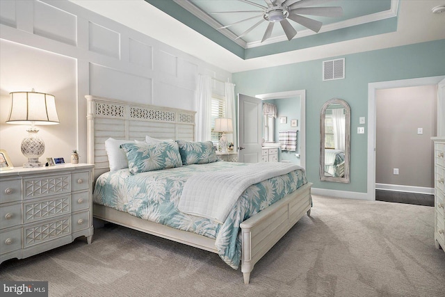 bedroom featuring a tray ceiling, ceiling fan, carpet, and ornamental molding