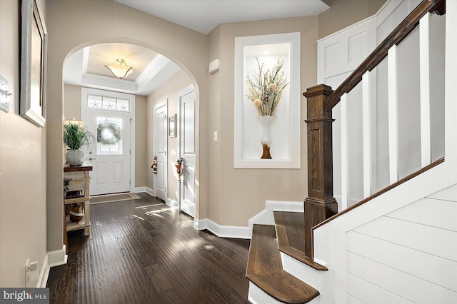 entrance foyer featuring dark hardwood / wood-style floors and a raised ceiling