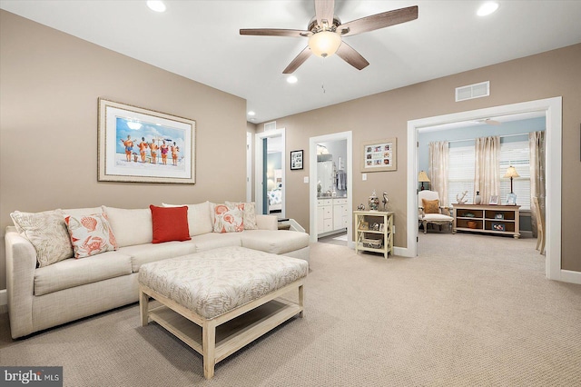 carpeted living room with ceiling fan