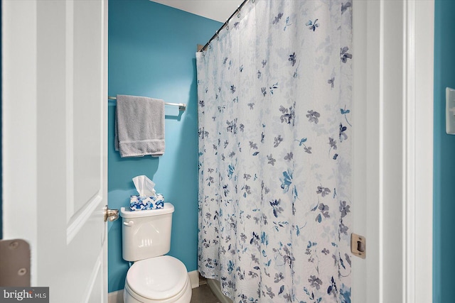 bathroom featuring a shower with curtain and toilet