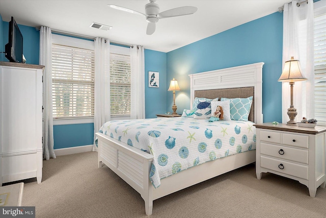 bedroom with light carpet, multiple windows, and ceiling fan