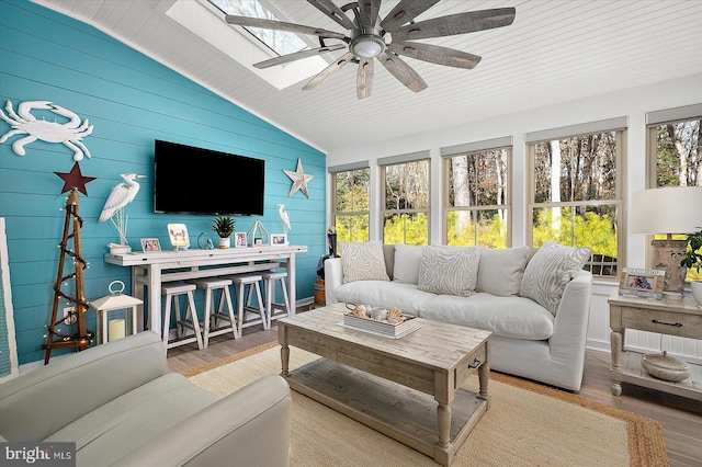 sunroom / solarium featuring a wealth of natural light, ceiling fan, and lofted ceiling with skylight