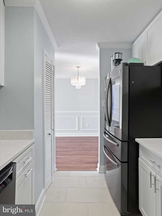 kitchen with dishwasher, an inviting chandelier, stainless steel fridge, decorative light fixtures, and white cabinetry