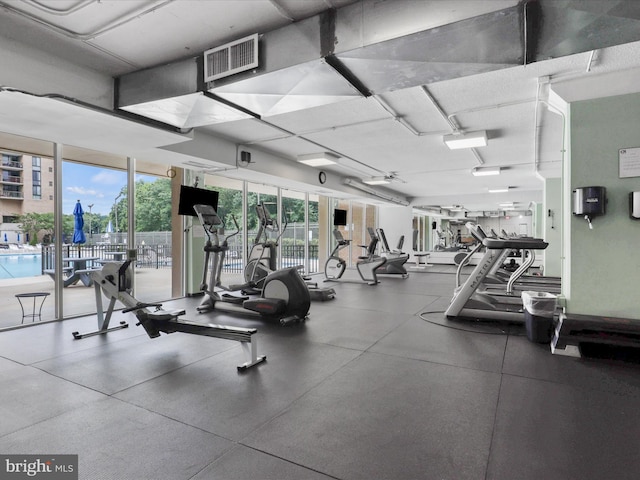 gym featuring a healthy amount of sunlight and a wall of windows