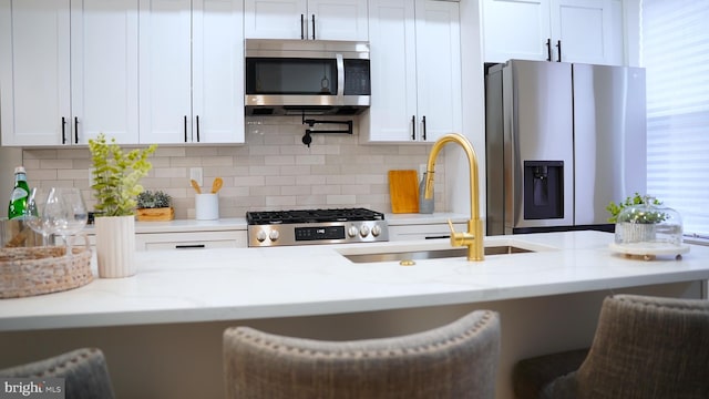 kitchen with light stone counters, white cabinets, and appliances with stainless steel finishes