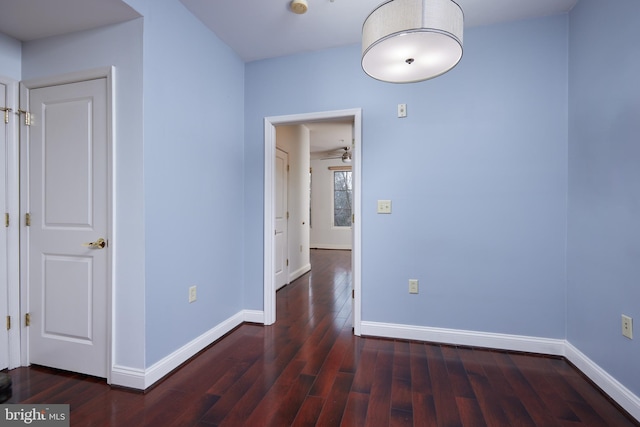 unfurnished room with dark hardwood / wood-style floors and ceiling fan