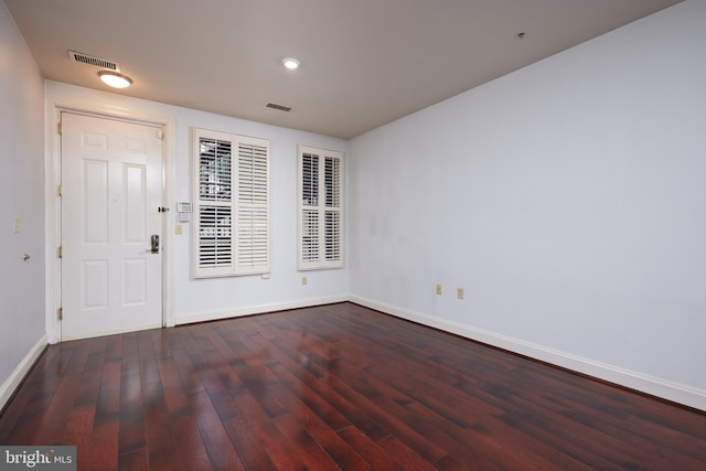 unfurnished room with dark wood-type flooring