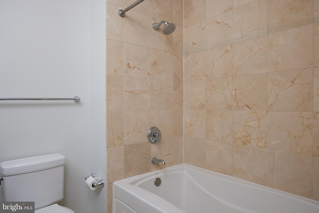 bathroom featuring toilet and tiled shower / bath