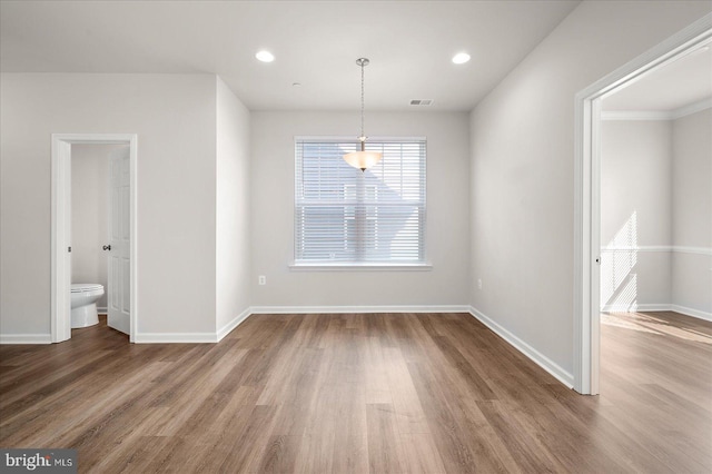 unfurnished dining area with wood-type flooring and ornamental molding