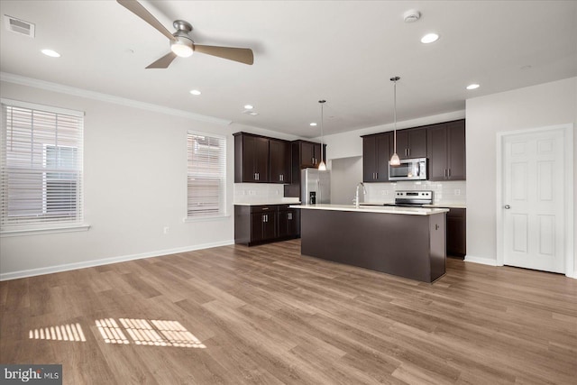 kitchen with crown molding, hanging light fixtures, hardwood / wood-style flooring, plenty of natural light, and stainless steel appliances