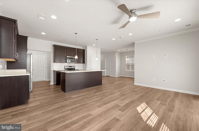 kitchen featuring pendant lighting, ceiling fan with notable chandelier, ornamental molding, light hardwood / wood-style floors, and stainless steel appliances