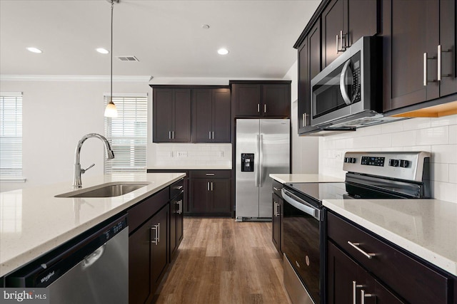 kitchen with hanging light fixtures, a healthy amount of sunlight, sink, and appliances with stainless steel finishes