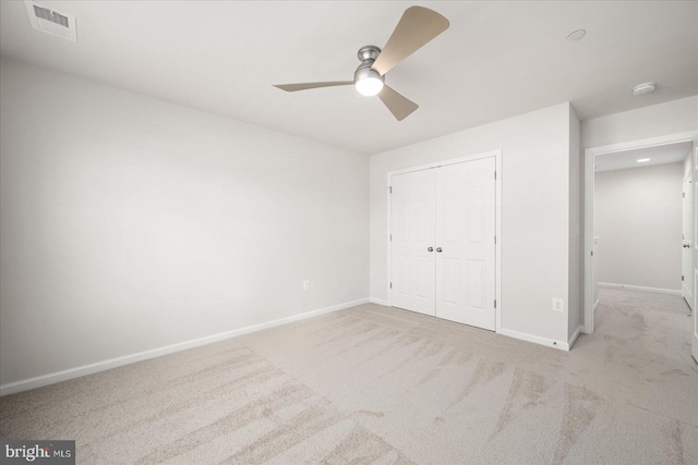 unfurnished bedroom with ceiling fan, a closet, and light colored carpet