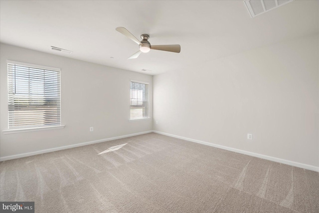 carpeted empty room with a wealth of natural light and ceiling fan