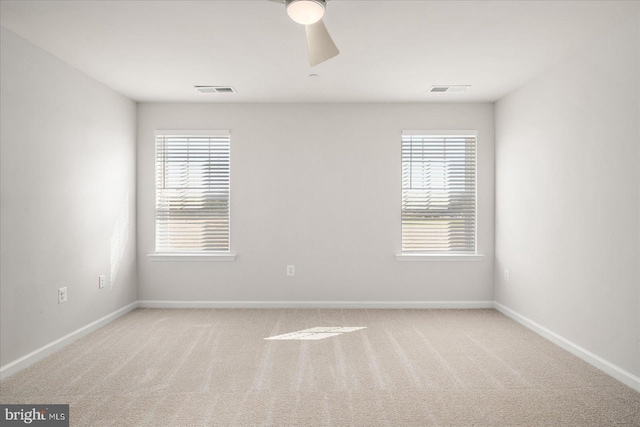 carpeted empty room with ceiling fan and a healthy amount of sunlight