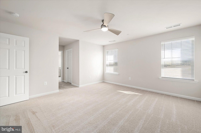 unfurnished bedroom with light carpet, multiple windows, and ceiling fan