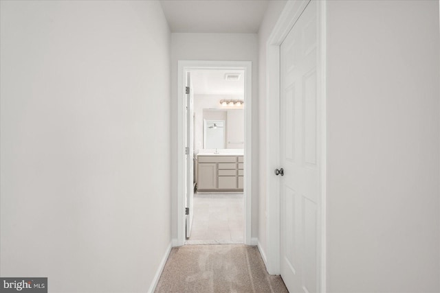 hallway featuring light colored carpet