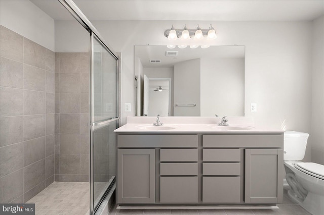 bathroom with tile patterned flooring, vanity, toilet, and walk in shower