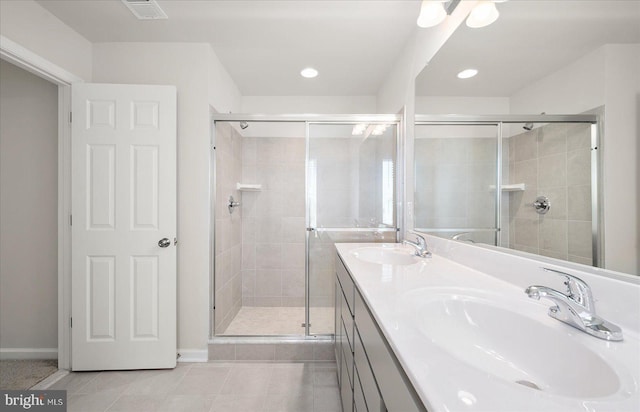 bathroom featuring tile patterned flooring, vanity, and a shower with door