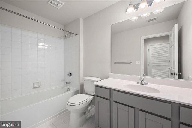 full bathroom featuring vanity, tile patterned flooring, tiled shower / bath, and toilet