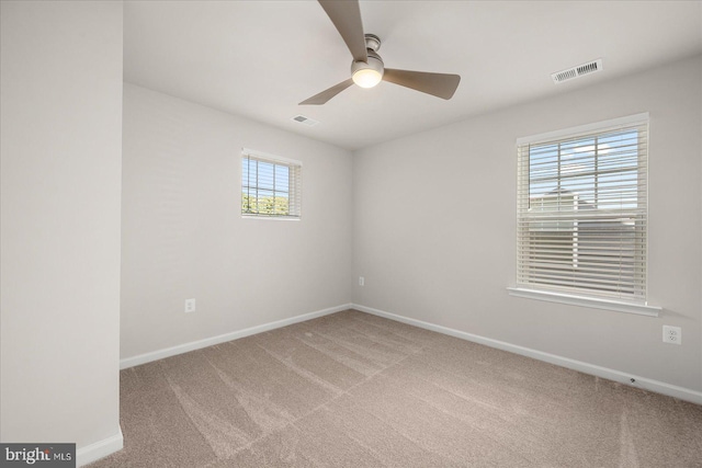 carpeted empty room featuring ceiling fan and a healthy amount of sunlight