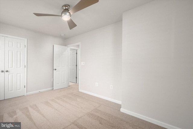 unfurnished bedroom featuring a closet, light colored carpet, and ceiling fan