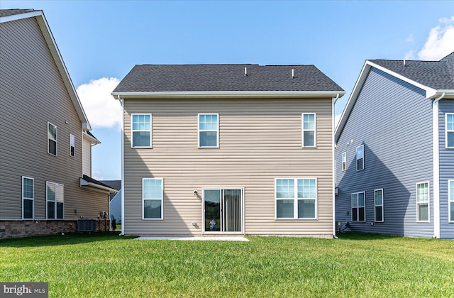 rear view of property featuring a yard and cooling unit