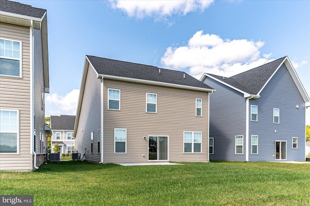 rear view of property featuring central air condition unit and a yard