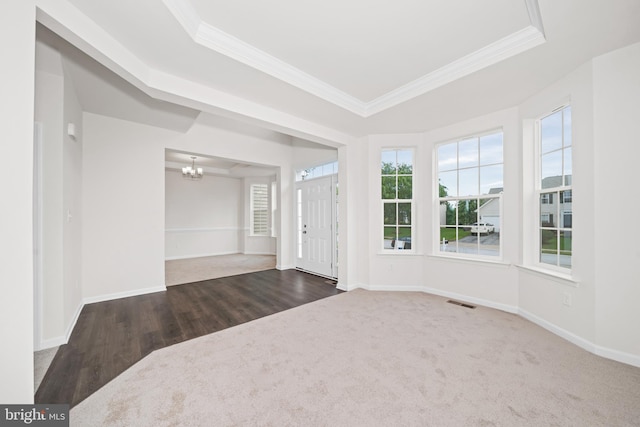 635 Corbit Dr, Middletown, DE 19709 - carpeted entrance foyer with ornamental molding, a chandelier, a tray ceiling, baseboards, and wood finished floors