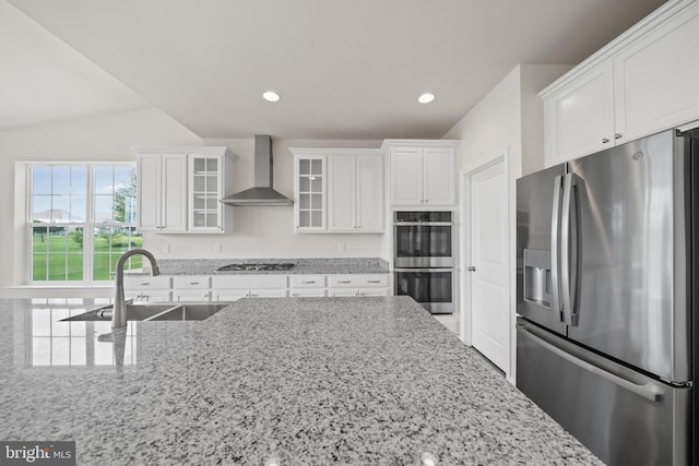 635 Corbit Dr, Middletown, DE 19709 - kitchen featuring appliances with stainless steel finishes, wall chimney range hood, white cabinetry, a sink, and glass insert cabinets