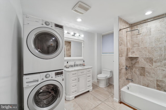 washroom featuring sink, light tile patterned floors, and stacked washer / drying machine