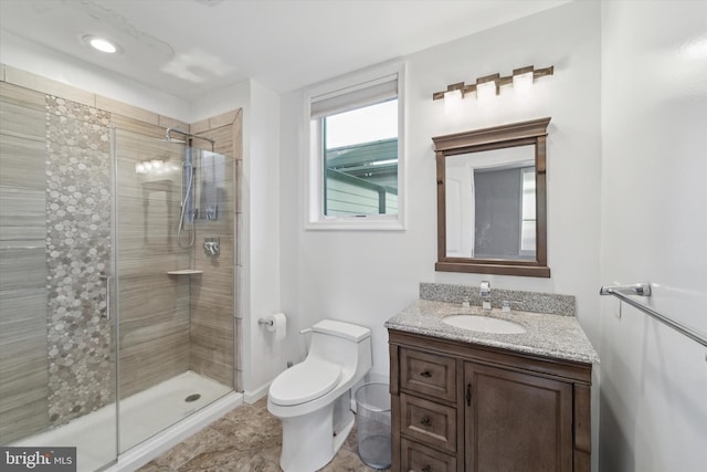 bathroom with an enclosed shower, vanity, and toilet