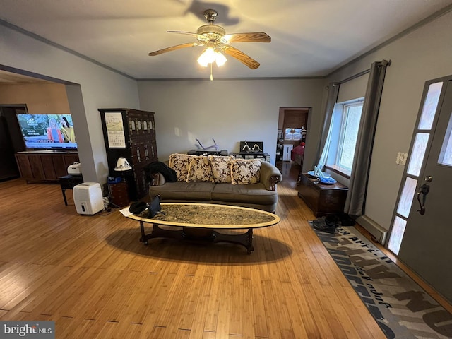 living room with ceiling fan, crown molding, and wood-type flooring