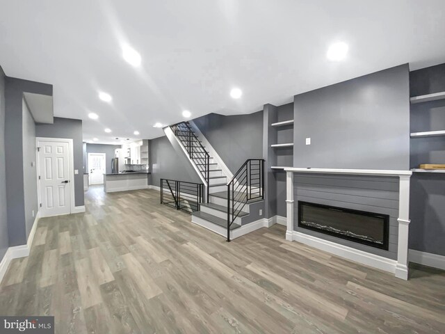 4827 N Warnock St, Philadelphia, PA 19141 - unfurnished living room with a glass covered fireplace, stairway, light wood-type flooring, and recessed lighting