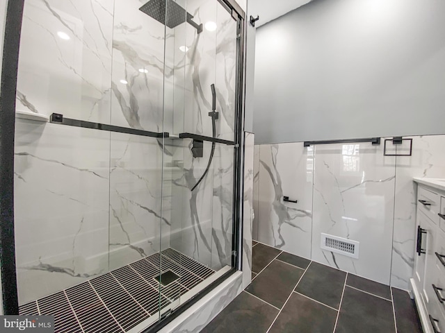 bathroom with tile patterned floors, a shower with door, and vanity