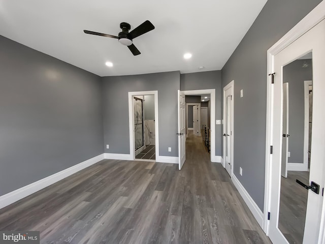 unfurnished bedroom with ensuite bath, ceiling fan, and dark hardwood / wood-style flooring