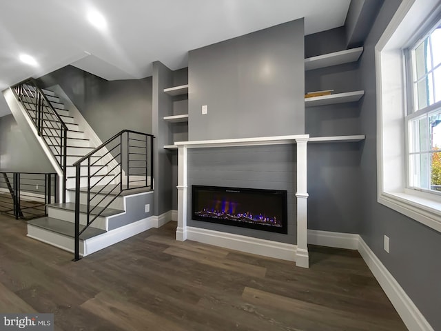 unfurnished living room with built in features and dark hardwood / wood-style floors