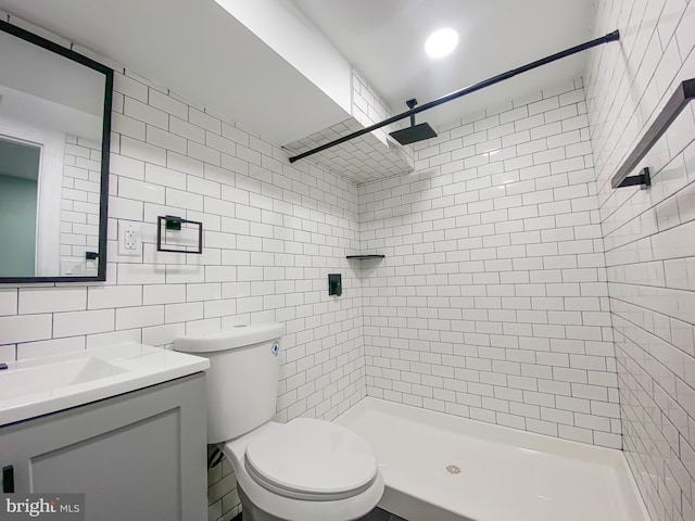 bathroom with tasteful backsplash, vanity, tile walls, and tiled shower