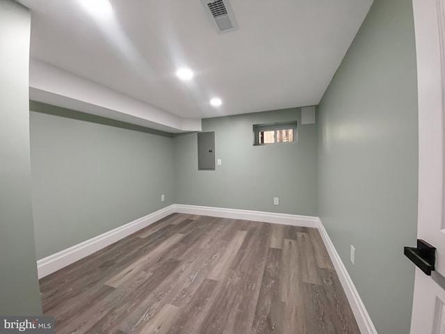 basement with electric panel and hardwood / wood-style flooring