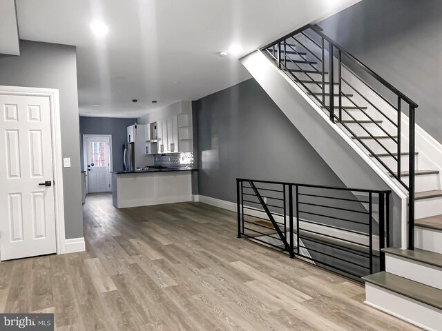 4827 N Warnock St, Philadelphia, PA 19141 - kitchen with appliances with stainless steel finishes, wall chimney range hood, dark countertops, decorative backsplash, and recessed lighting
