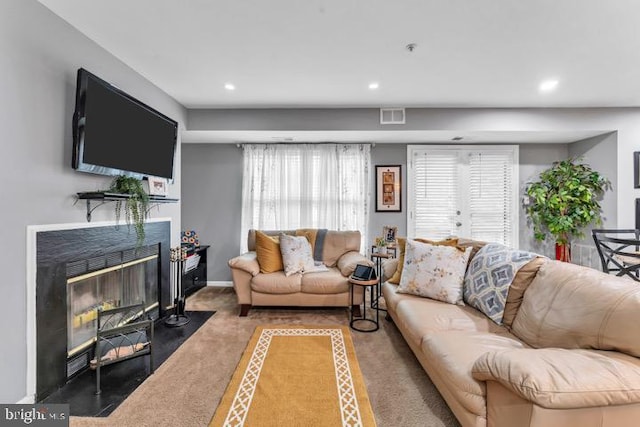 living room with carpet and a premium fireplace