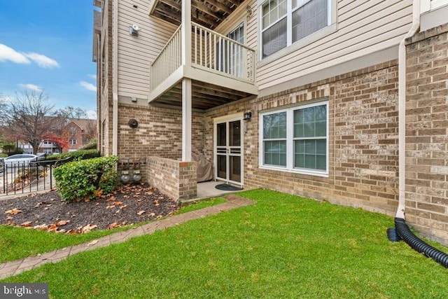 doorway to property with a lawn and a balcony