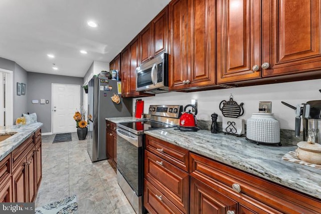 kitchen featuring light stone countertops and appliances with stainless steel finishes