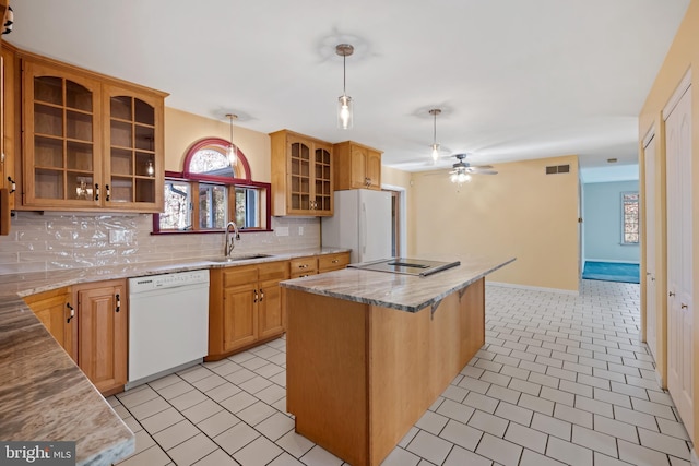 kitchen with decorative backsplash, white appliances, sink, decorative light fixtures, and a center island