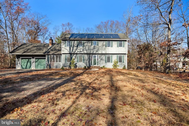 view of front of house featuring solar panels and a garage